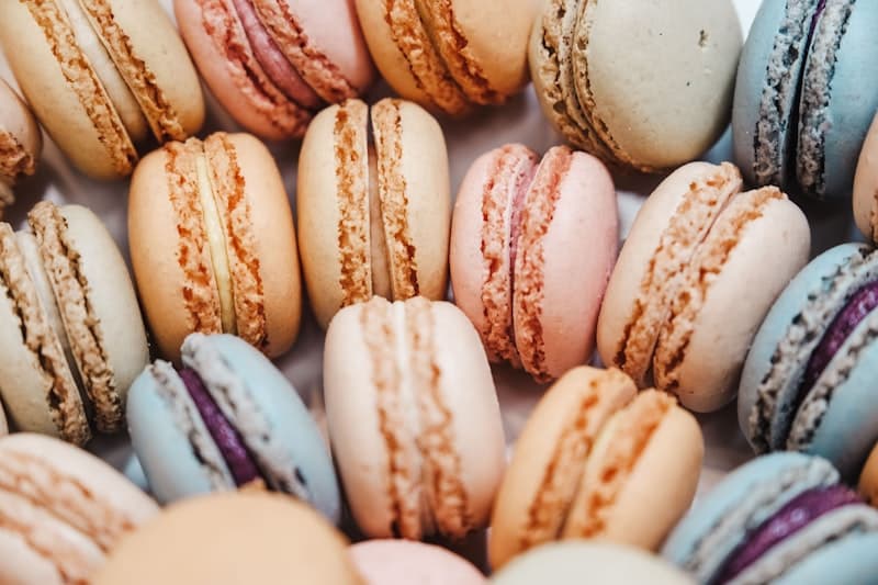 Rows of pastel macarons on a marble counter